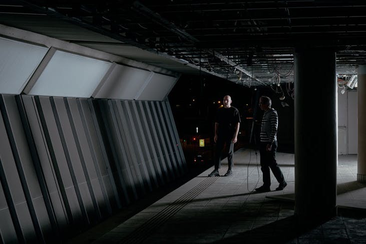 Artists installing sound and lighting at an abandoned monorail station in Sydney.
